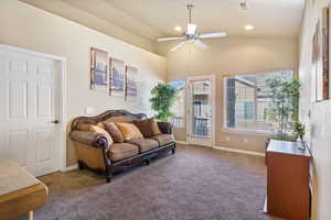 Carpeted living room with vaulted ceiling, a ceiling fan, and recessed lighting