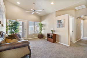 Living area featuring vaulted ceiling, light colored carpet, ceiling fan, and recessed lighting