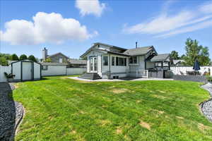 Rear view of property featuring a patio, a fenced backyard, a storage unit, and entry steps