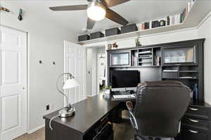 Carpeted office featuring a ceiling fan and baseboards