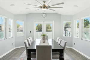 Dining space featuring healthy amount of natural light, lofted ceiling, wood finished floors, and ceiling fan