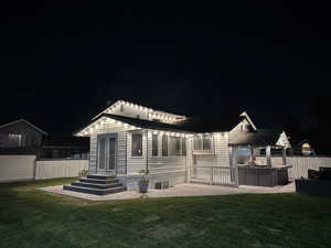 Back of house at night featuring a patio area