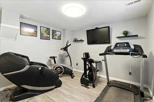 Workout room with light wood finished floors and baseboards