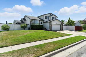 Tri-level home with concrete driveway, stone siding, and a garage