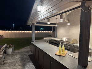 Patio at night featuring a patio area and exterior kitchen