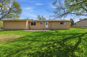 Back of property featuring a lawn and entry steps