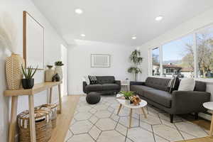 Living area with light wood-style flooring, recessed lighting, and a baseboard radiator