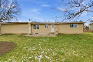 Rear view of property with a yard and a patio area