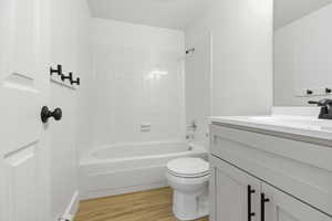 Full bath with vanity, shower / washtub combination, and light wood-type flooring