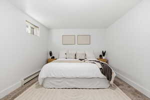Carpeted bedroom featuring baseboard heating and baseboards