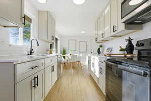 Kitchen featuring stainless steel appliances, light wood-type flooring, and healthy amount of natural light