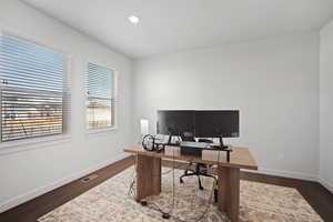 Home office featuring dark wood-style flooring and recessed lighting