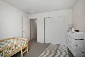 Bedroom featuring carpet flooring, a closet, and a textured ceiling