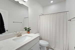 Full bath featuring vanity, a shower with shower curtain, and recessed lighting