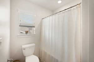 Full bathroom with curtained shower and recessed lighting
