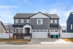 View of front of property featuring a gate, roof with shingles, a mountain view, and a garage