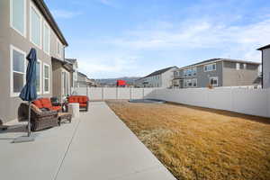 Fenced backyard featuring a patio area, a residential view, an outdoor lounge area, and a mountain view