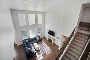 Living area with dark wood-type flooring, recessed lighting, and a high textured ceiling