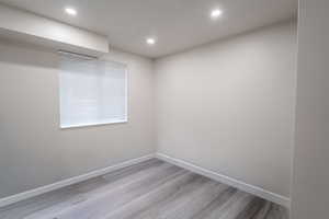 Empty room featuring light wood-type flooring and recessed lighting