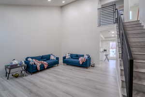 Living area featuring a high ceiling, recessed lighting, and light wood-style flooring