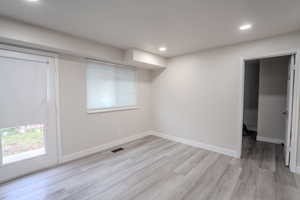 Basement featuring light wood-style floors, recessed lighting, and healthy amount of natural light