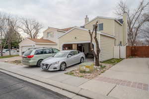 View of front of home featuring a chimney, concrete driveway, and a gate
