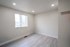 Spare room with light wood finished floors and recessed lighting
