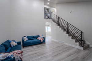 Living area featuring a high ceiling, light wood-style floors, and recessed lighting