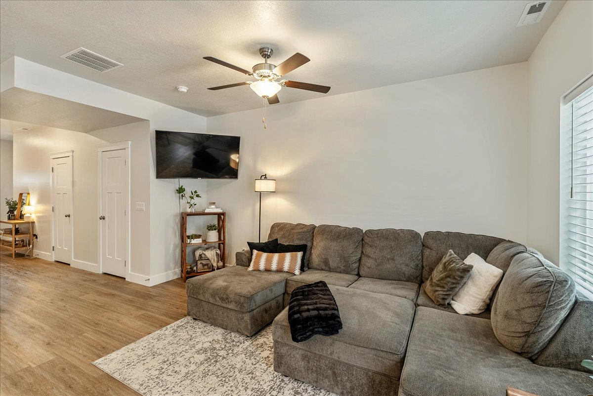 Living room with ceiling fan and light wood-style flooring