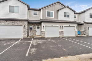 View of front of house featuring stone siding, board and batten siding, and a garage