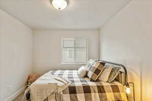 Bedroom featuring carpet flooring and a textured ceiling