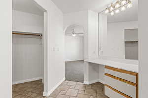 Bathroom with a walk in closet and stone finish floors