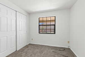 Unfurnished bedroom featuring carpet floors and a closet