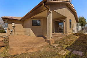 Back of property with stucco siding, a tiled roof, and a patio