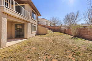Fenced backyard with a balcony and a patio