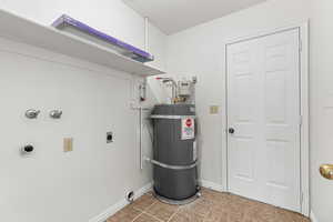 Laundry area featuring washer hookup, water heater, hookup for an electric dryer, and light tile patterned floors