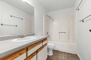 Bathroom with vanity, bathtub / shower combination, and a textured wall