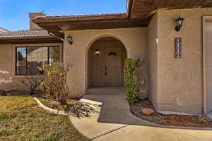 Property entrance with stucco siding and a tile roof