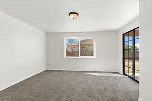Carpeted spare room with baseboards and a textured ceiling