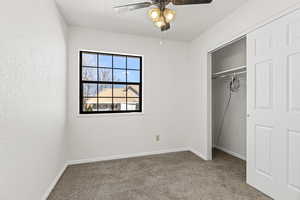 Unfurnished bedroom featuring a closet, carpet, and ceiling fan