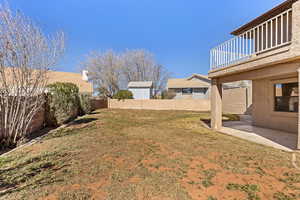 Fenced backyard featuring a balcony and a patio area