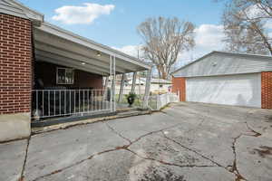 View of property exterior with a garage, an outbuilding, and brick siding