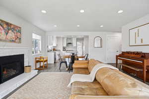 Living room featuring a glass covered fireplace, dark wood finished floors, and recessed lighting