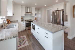 Kitchen featuring stainless steel appliances, recessed lighting, white cabinets, dark wood finished floors, and a center island