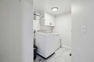 Laundry area featuring cabinet space and washing machine and clothes dryer