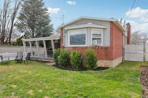 View of property exterior with a fenced backyard, brick siding, and a chimney