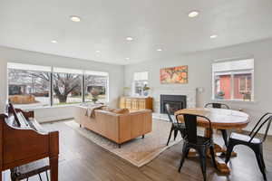 Living area with wood finished floors, a fireplace, recessed lighting, and healthy amount of natural light