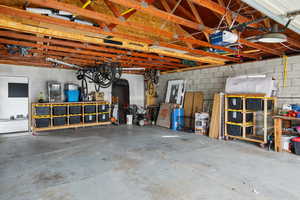 Garage featuring concrete block wall and a garage door opener