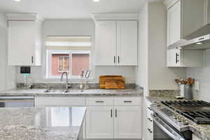 Kitchen with plenty of natural light, stainless steel appliances, light stone counters, and recessed lighting