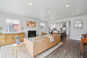 Living room featuring dark wood finished floors, a brick fireplace, and recessed lighting